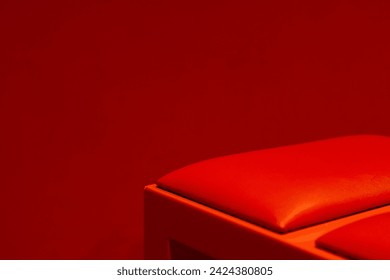 A striking minimalist composition with a rich red hue enveloping a simple object, embodying the essence of color impact and modern interior design with comfort bench furniture in the theatre room