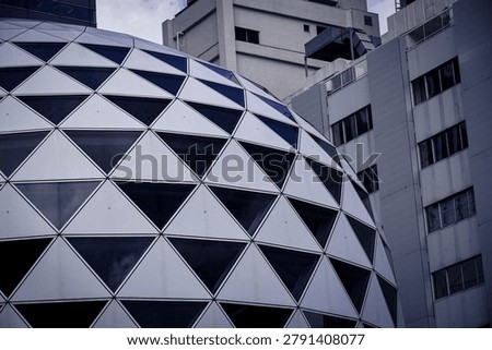 A striking spherical architectural structure composed of interconnected triangular panels, creating a geometric dome design.