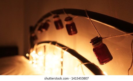                     String Of Amber Bottles On Bedroom Bed Head With Twinkle Lights Retro Vintage Style            