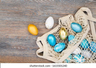 String bag with Easter eggs in corner of a rustic wooden table