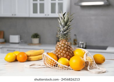 String bag with fresh fruits on light table in kitchen - Powered by Shutterstock