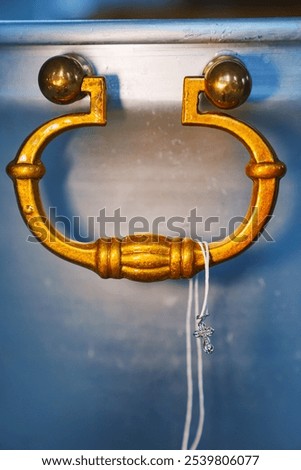 a string with a baptismal cross on the handle of the baptismal font. attributes of the baptism ceremony.