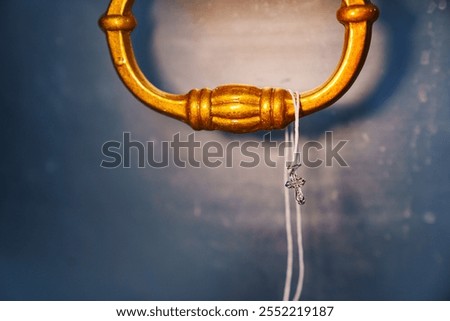 a string with a baptismal cross on the handle of the baptismal font. attributes of the baptism ceremony.