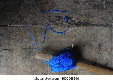 A string of blue plastic straps on a wooden base.