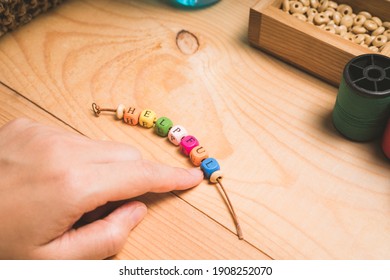 String a bracelet Wooden letter beads of Helpful word, Close up woman hand string with a colourful Wooden letter beads, mood and tone concept. - Shutterstock ID 1908252070