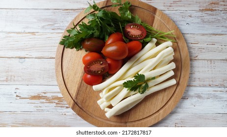 String Cheese Or Cheese Whip - Salty Snack Cheese With Cherry Tomatoes And Herbs On Chopping Board. Turkish Cheese