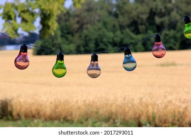 A string of colored electric lights on a landscape background. Selective focus 
