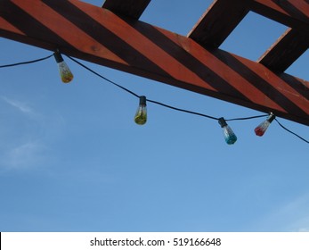 String of colored lights hanging from pergola roof
