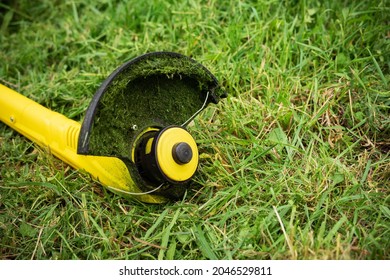 String Grass Trimmer In A Mowed Meadow.