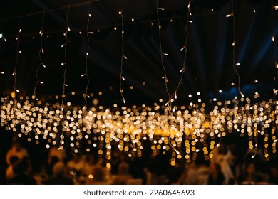 String led fairy lights in warm yellow tone at a party at night.
