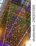 String lights hanging from a multi coloured glass ceiling
