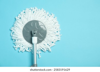 String mop on light blue background, top view. Space for text