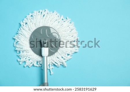 String mop on light blue background, top view. Space for text