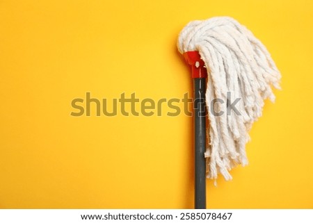 String mop on yellow background. Space for text