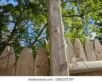 A string of solar star lights running along a wooden fence panel.