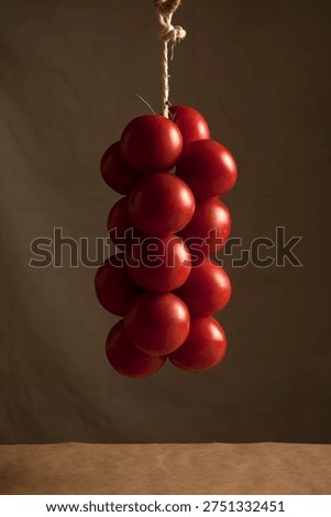 String of tomatoes to hang on rustic background 