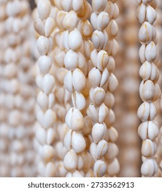 A string of white beads with a yellow stripe. The string is long