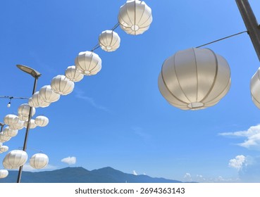 String of White Lanterns Against Clear Blue Sky