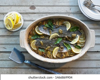 Striped Bass With Potatoes And Olives In A Casserole Dish 