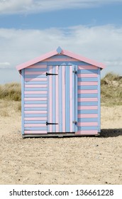 A Striped Beach Hut On A UK Shore.