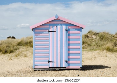 A Striped Beach Hut On A UK Shore.