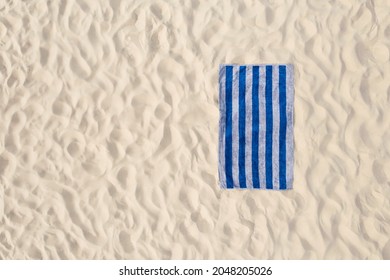 Striped Beach Towel On Sand, Aerial View. Space For Text