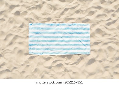 Toalla de playa rayada sobre la arena, vista aérea