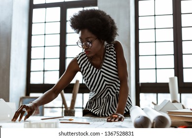 Striped blouse. African-American interior designer wearing striped blouse working hard in the office