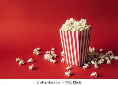 Striped box with popcorn on red background - Shutterstock ID 746312602