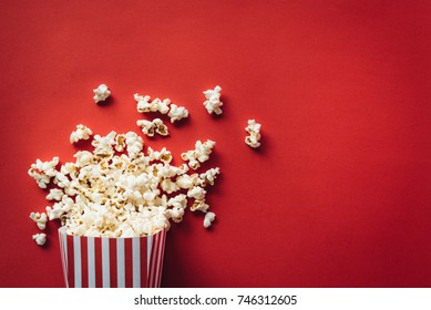 Striped box with popcorn on red background