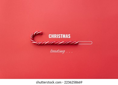 Striped candy cane and lettering Christmas loading on red background. Concept of waiting for seasonal holidays. Copy space, selective focus - Shutterstock ID 2236258669