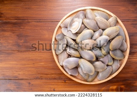 Striped Clam or Clam bivalve molluscs  on wooden background for seafood dish.