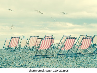 Striped Deck Chairs On English Beach With Seagulls