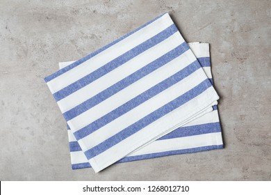 Striped fabric napkins on gray background, top view