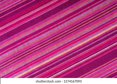 Striped fabric texture with multiple warm colors (purple, purple, magenta, pink, red, maroon, orange, yellow). Close-up of the tissue. Ethnic aspect - Powered by Shutterstock