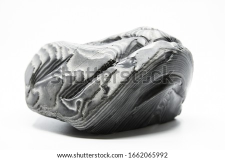 Striped flint stone isolated on a white background. Amazing curves and stripes. Grey colors and amazing lines