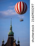 Striped hot air balloon flying next to a castle tower in Budapest City Park