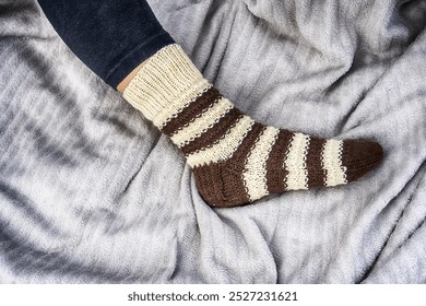 Striped knitted sock on foot- education, magazines and marketing - Powered by Shutterstock