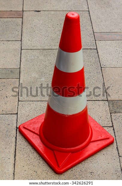 striped orange\
cones stand on gray asphalt\
road