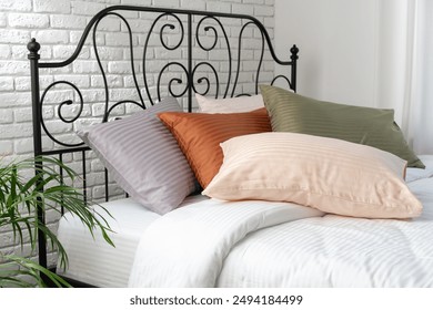 Striped Pillows on a Bed With Black Metal Headboard - Powered by Shutterstock