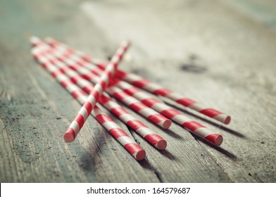 Striped straws for cocktails on wooden background