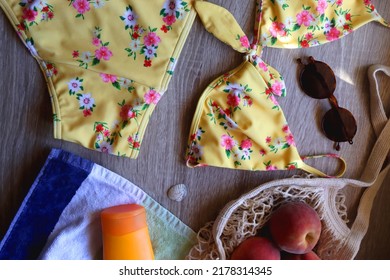 Striped Towel, Yellow Floral Swimming Suit, Sunglasses, Mesh Tote With Fresh Peaches, Seashell And Sunscreen. Beach Essentials, Flat Lay.