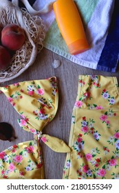 Striped Towel, Yellow Floral Swimming Suit, Sunglasses, Mesh Tote With Fresh Peaches, Seashell And Sunscreen. Beach Essentials, Flat Lay.