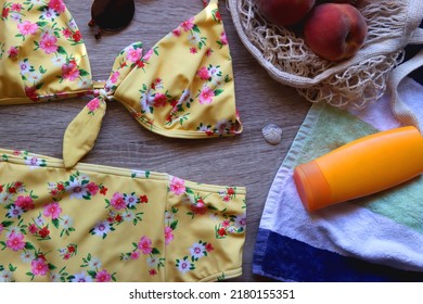 Striped Towel, Yellow Floral Swimming Suit, Sunglasses, Mesh Tote With Fresh Peaches, Seashell And Sunscreen. Beach Essentials, Flat Lay.