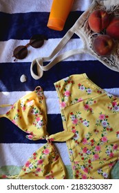 Striped Towel, Yellow Floral Swimming Suit, Sunglasses, Mesh Tote With Fresh Peaches, Seashell And Sunscreen. Beach Essentials, Flat Lay.