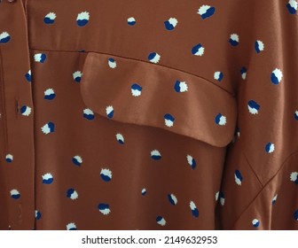 Stripes On Natural Fabric Sewn Into A Shirt With Buttons The Graphic On The Fabric Is A Natural Pattern Of Brown And Dark Blue, Alternating Patterns As A Focal Point.