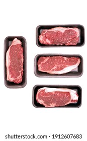 Striploin Beef Steak In Foamed Tray Isolated On White Background, Overhead View. Uncooked Prime Beef Raw Steak. Single Raw Sirloin Steak From Marbled Beef On White Background. 