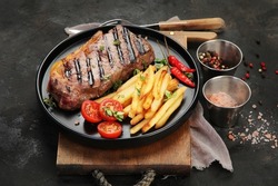 Striploin Beef Steak With French Fries On Dark Background. Freshly Grilled. Healthy Dinner. Mediterranean Diet. 