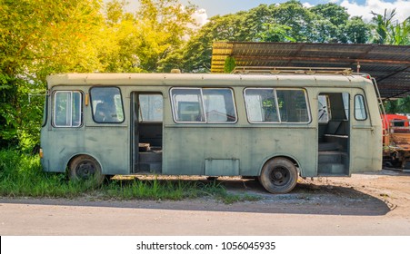 Stripped rusty, old abandoned blue bus left side view wreck in the street with orange flare. - Powered by Shutterstock