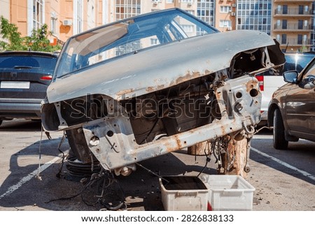Stripped vehicle front with missing engine parts, automotive dismantling, salvage and recycling